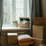 Stack of moving boxes in a sunlit room, symbolizing a fresh start in a new apartment.