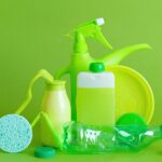 Monochrome green bottles and containers for liquids or gel with plastic bottle and lids on green background